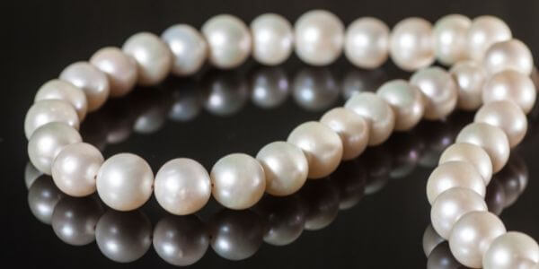 White-freshwater-pearl-necklace-with-reflection-on-black-surface
